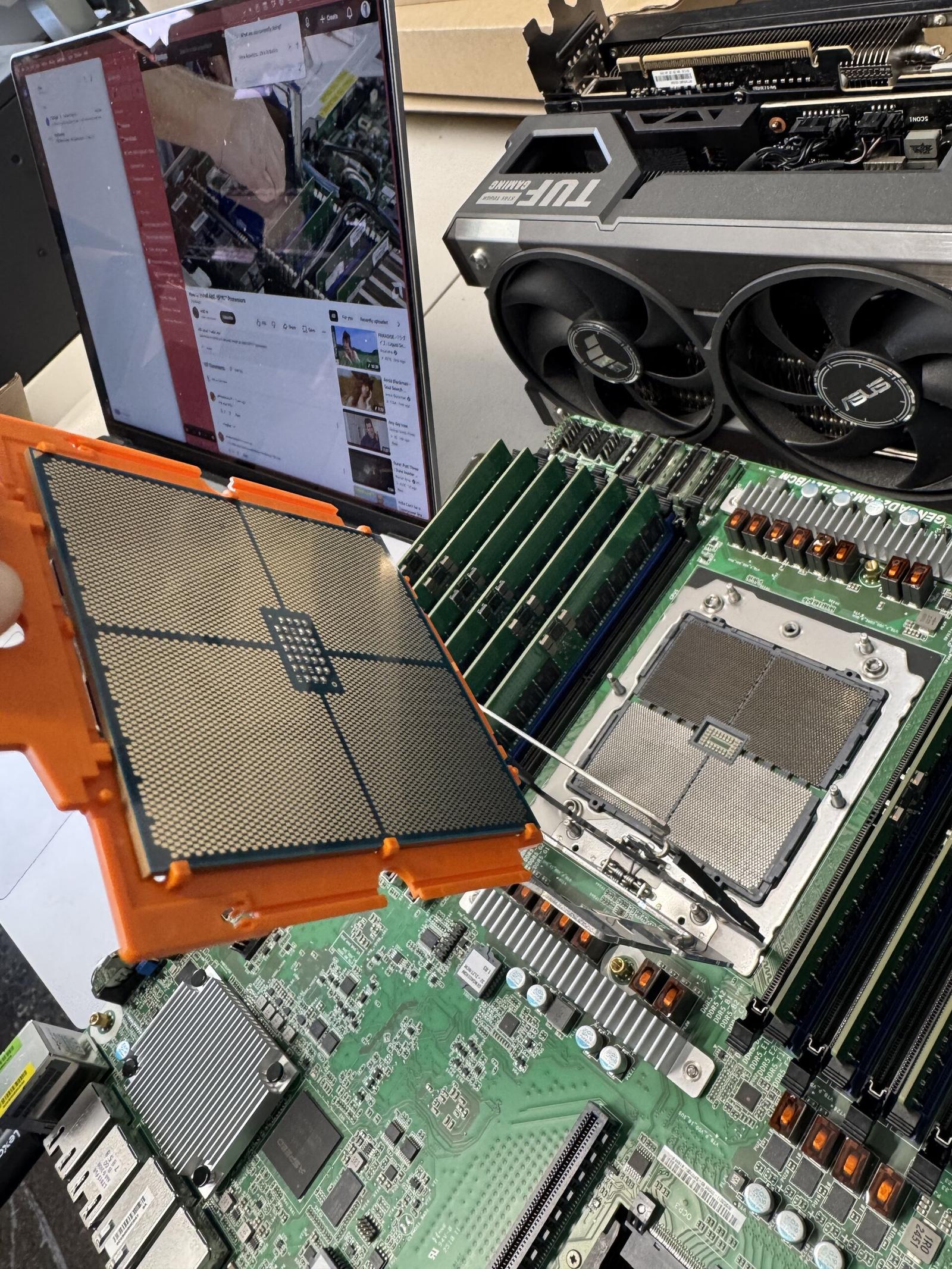 The CPU in its carrier, over the socket. There are 6,096 pins under there.